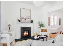 Bright living room featuring a cozy fireplace, white walls, and stylish decor creating a warm and inviting atmosphere at 3346 W 30Th Ave, Denver, CO 80211