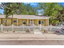Charming single-story home with a white picket fence and a well-maintained, xeriscaped front yard at 525 Willow Dr, Brighton, CO 80603