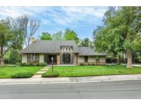Charming ranch-style home with mature landscaping, stepping stone pathway, and a well-maintained lawn at 7295 S Steele Cir, Centennial, CO 80122