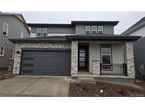 Charming two-story home with a gray exterior, stone accents, and a two-car garage at 7279 Prairie Sage Pl, Littleton, CO 80125