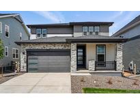 Modern two-story home featuring stone accents, a gray color scheme, and a two-car garage at 7279 Prairie Sage Pl, Littleton, CO 80125