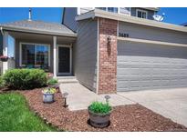 Inviting front entrance of the two-story home, featuring a gray exterior and a well-manicured garden at 3689 Primrose Ln, Castle Rock, CO 80109