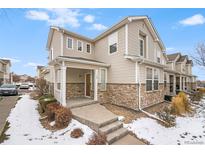Charming two-story townhome with stone accents and covered entry during a winter season at 9758 Laredo St # 30E, Commerce City, CO 80022