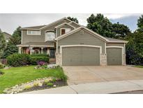Charming two-story home featuring a landscaped yard and a spacious three-car garage at 8229 Cottongrass Ct, Castle Pines, CO 80108