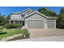 Charming two-story home featuring an attached three-car garage and beautifully landscaped front yard at 8229 Cottongrass Ct, Castle Pines, CO 80108