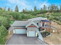 Aerial view of a house nestled in a mountainside setting with a large yard at 4840 Limestone Rd, Monument, CO 80132