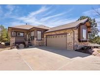 Charming home with stone accents, a two-car garage, and a cozy front porch sitting area at 7370 S Catawba Way, Aurora, CO 80016
