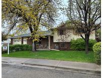 Charming brick and siding home with mature landscaping and a cozy front patio area at 710 S Grand Ave, Fort Lupton, CO 80621