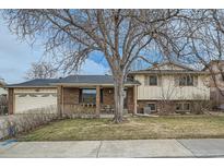 Charming two-story home featuring a well-maintained lawn and mature landscaping with a beautiful tree at 710 S Grand Ave, Fort Lupton, CO 80621