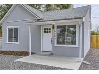 Charming home featuring a quaint front entrance with a white door, fresh paint, and tasteful landscaping at 6880 Pontiac St, Commerce City, CO 80022