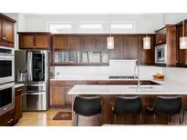Gourmet kitchen features stainless steel appliances and a sleek breakfast bar at 7080 W Custer Ave, Lakewood, CO 80226
