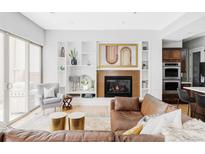 Inviting living room features a cozy fireplace, custom built-ins, and sliding glass door to the outside at 7080 W Custer Ave, Lakewood, CO 80226