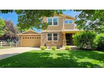 Charming two-story home featuring a stone facade, well-manicured lawn, and an attached two-car garage at 14232 Piney River Rd, Broomfield, CO 80023