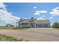Charming two-story home featuring a welcoming front porch and an attached three-car garage at 32800 E 137Th Way, Brighton, CO 80603