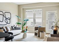 Bright living room features large window, comfortable seating and stylish décor, creating an inviting and modern space at 1975 N Grant St # 810, Denver, CO 80203