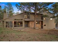 Charming home featuring stone accents, wood siding and a front yard with mature trees at 2386 Daisy Ln, Golden, CO 80401