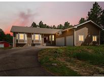 Charming ranch-style home with a driveway and a two-car garage on a large lot with mature trees at 20125 Indi Dr, Monument, CO 80132