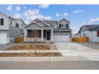Beautiful two-story home with a two-car garage and a covered front porch entrance at 9996 Racine St, Commerce City, CO 80022