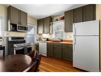 Galley kitchen featuring wood countertops, cabinetry, stainless steel appliances, and hardwood floors at 2886 S Acoma St, Englewood, CO 80110