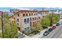 Modern multi-story townhouse with balconies and a ground-level patio in a vibrant neighborhood setting at 3295 Blake St # 301, Denver, CO 80205