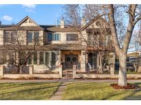 Charming two-story home with a well-manicured lawn and wrought iron fence at 2805 E 4Th Ave, Denver, CO 80206