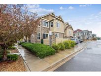 Charming two-story townhouse showcasing stone and siding accents with manicured front yard landscaping at 23535 E Platte Dr # A, Aurora, CO 80016