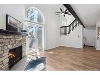 Bright living room features a stone fireplace, wood floors, and vaulted ceilings with a large window at 921 S Zeno Way # 201, Aurora, CO 80017