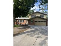 Charming two-story home with a brick facade, attached two-car garage, and spacious driveway at 12625 W 66Th Cir, Arvada, CO 80004