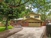 Two-story home featuring a charming brick facade and attached two-car garage at 12625 W 66Th Cir, Arvada, CO 80004