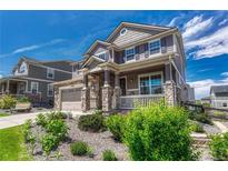 Charming two-story home with a stone facade, manicured front yard, and inviting front porch at 23957 E Rocky Top Ave, Aurora, CO 80016