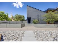 Modern home featuring a landscaped front yard with a secure fence and unique architectural design at 2801 Lawrence St, Denver, CO 80205