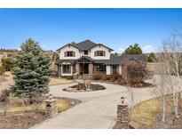 A beautiful two-story home with a circular driveway and stone accents at 5375 Twilight Way, Parker, CO 80134
