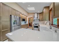 Bright kitchen features stainless steel appliances, quartz countertops, and ample cabinet space at 8944 W 66Th Pl, Arvada, CO 80004