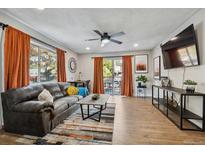 Open living room with wood floors, comfortable seating, and access to a private balcony at 7755 E Quincy # 201, Denver, CO 80237