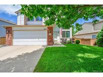 Charming two-story home with a lush green lawn and a two car garage at 9717 Castle Ridge Cir, Highlands Ranch, CO 80129