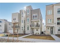 Striking townhome featuring a blend of stone and siding, a front balcony, and modern architectural design at 11223 W 53Rd Pl, Arvada, CO 80002