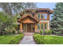 Charming home featuring a beautiful wood facade, brick accents, and a welcoming entryway with landscaped yard at 1410 S Elizabeth St, Denver, CO 80210