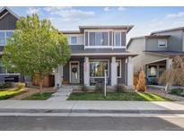 Charming two-story home features a covered front porch and well-maintained landscaping at 6834 Clay N St, Denver, CO 80221