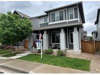 Charming two-story home with a well-maintained lawn and inviting front porch at 6834 Clay N St, Denver, CO 80221