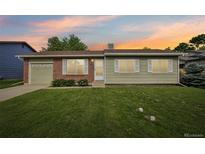 Charming single-story home featuring a well-manicured lawn, brick accents, and a convenient attached garage at 4759 S Xenophon St, Morrison, CO 80465