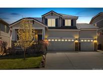 Inviting two-story home with a three car garage, solar panels and beautiful landscaping at dusk at 2208 Bellavista St, Castle Rock, CO 80109