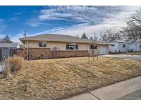 A charming ranch-style house with brick and siding, a well-manicured lawn, and an attached one-car garage at 454 S Jay St, Lakewood, CO 80226