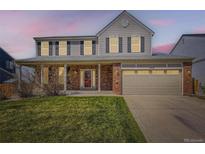 Charming two-story home features a covered porch, attached two-car garage, and well-maintained lawn at 11715 Crow Hill Dr, Parker, CO 80134