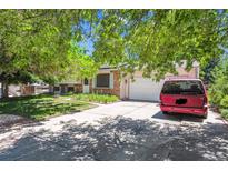 Charming single-story home with a brick facade, well-manicured lawn, and a mature tree in front at 2516 S Cimarron St, Aurora, CO 80014