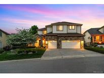 Beautiful two-story home featuring a stone facade, spacious garage, manicured lawn, and beautiful landscaping at 6427 S Tibet St, Aurora, CO 80016