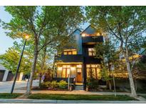 Charming two-story home boasting a blend of modern design and classic elegance, surrounded by mature trees and lush landscaping at 920 Neon Forest Cir, Longmont, CO 80504