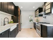 Modern kitchen featuring black cabinets, white countertops, subway tile backsplash, and stainless steel appliances at 3625 W 9Th Ave, Denver, CO 80204