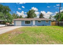 Charming blue single-story home with a well-manicured lawn and a one car garage, bathed in sunlight at 1552 W Caley Ave, Littleton, CO 80120