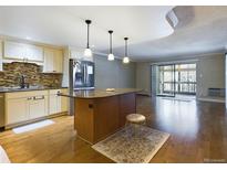 Updated kitchen with island, stainless steel appliances, and hardwood floors at 14000 E Linvale Pl # 110, Aurora, CO 80014