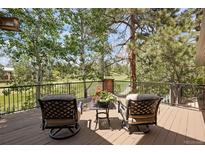 Inviting deck with comfortable seating and stunning golf course views surrounded by mature trees at 120 Silver Leaf Way, Castle Rock, CO 80108